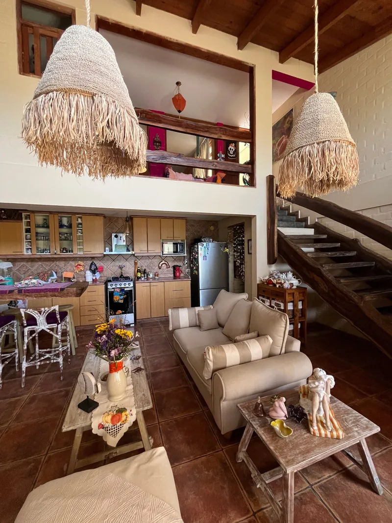 Sala de doble altura con cocina abierta y escalera