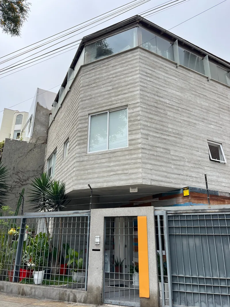 Fachada de la casa con jardín y reja