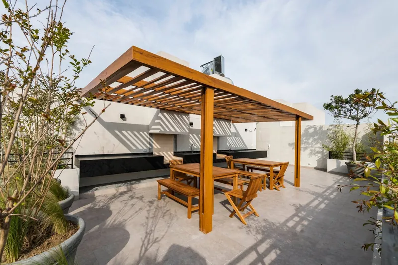 Zona de parrilla con pérgola de madera