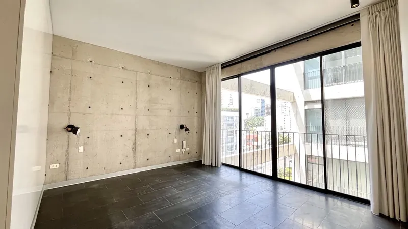Dormitorio con muro de concreto expuesto